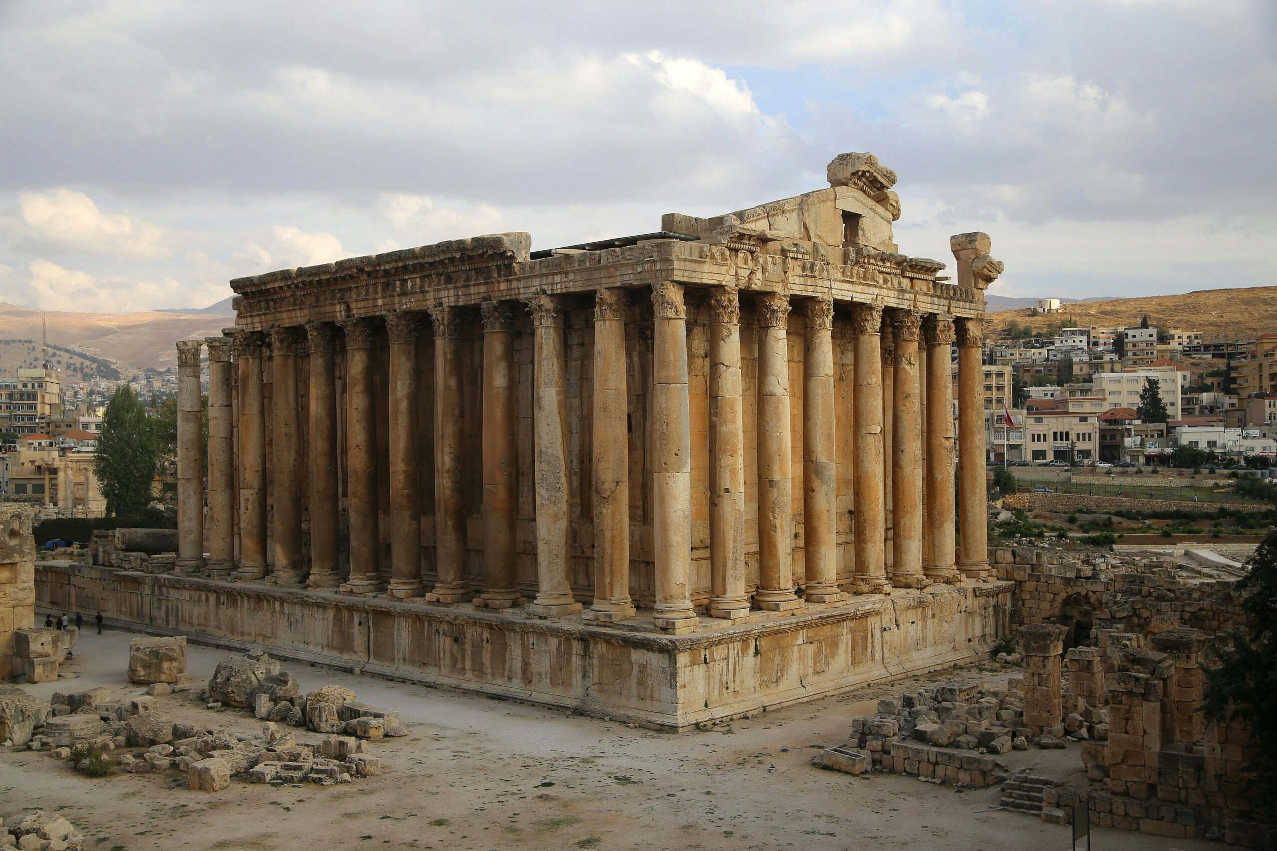 roman temple ruins at baalbek, lebanon, with rows of stone columns and surrounding archaeological remains.