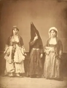 Historic studio photograph of three Lebanese women wearing traditional regional clothing, including embroidered dresses and head coverings.