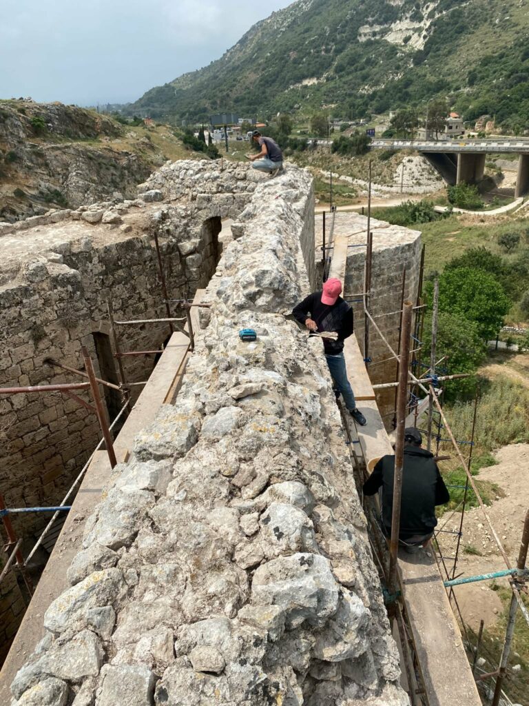 Conservation workers carrying out restoration work on the stone walls of Mseilha Castle in Lebanon